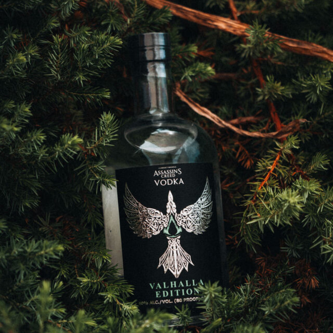 Bottle of vodka with a decorative label on green foliage.