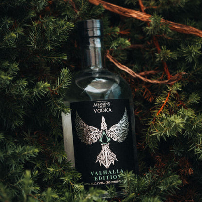 Bottle of vodka with a decorative label on green foliage.